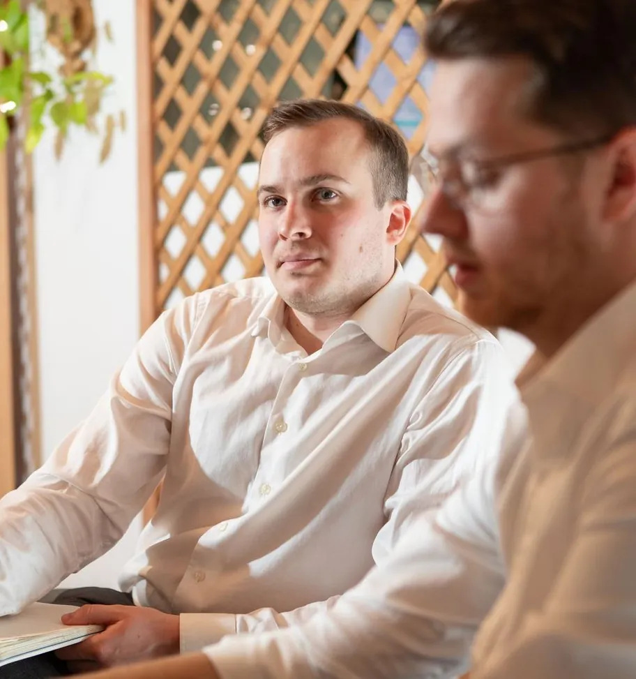 Two men collaborating at wooden partitions